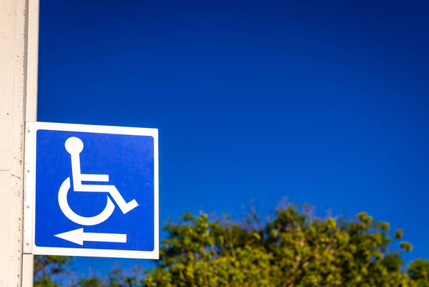 Panneau carré bleu pour indiquer le chemin aux personnes handicapées dans un petit coin
 - Photo, image