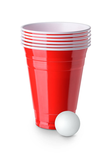 Cerveja-pongue. Copos de plástico vermelho e ping pong bola solada em branco
  - Foto, Imagem