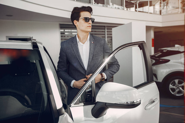 Handsome and elegant man in a car salon - Photo, image