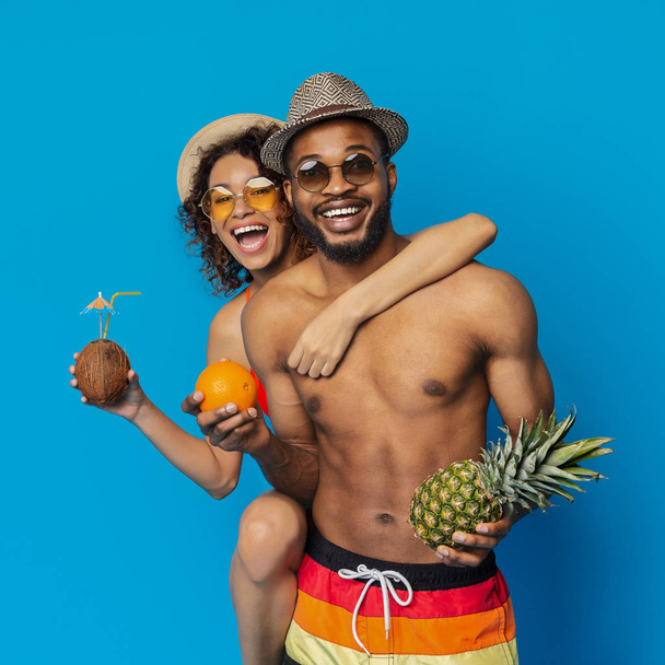 Happy african couple enjoying tropical fruits and cocktail - Photo, Image