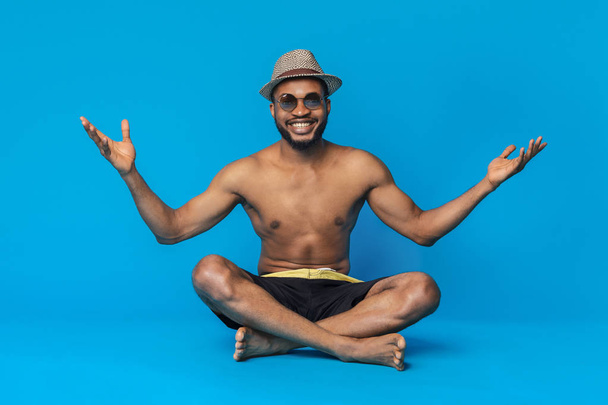 Happy black guy in swimwear chilling out on blue studio background - Photo, image