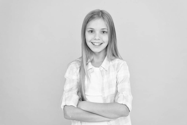 Kid girl blonde hair posing confidently. Girl feels confident with crossed arms. Child hold hands confidently crossed chest. Child psychology and development. Confident posture. Upbringing confidence - Photo, Image