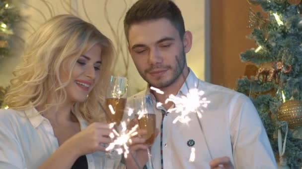 Slow Motion Happy Couple Light Sparklers And Smile In The Christmas Background  - Materiał filmowy, wideo
