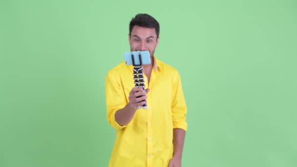 Happy young Hispanic businessman vlogging and showing phone - Video, Çekim