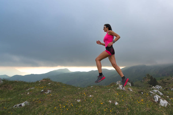 Trail lopen in de heuvels. Een vrouwelijke atleet - Foto, afbeelding