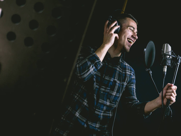 The young guy singing in recording studio - Фото, изображение