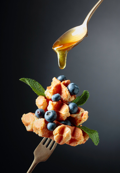 Gofres belgas caseros con miel, arándanos y menta en un dar
 - Foto, Imagen