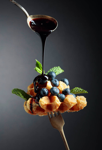 Homemade Belgian waffles with  chocolate syrup, blueberry and mi - Photo, Image