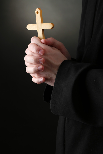 Priest holding cross, on black background - Fotó, kép