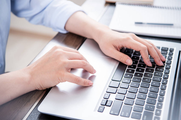 Бізнес-концепція. Жінка в синій сорочці, що друкує на комп'ютері з кавою на офісному столі, підсвічування, ефект відблиску сонця, крупним планом, вид збоку, місце для тексту
 - Фото, зображення