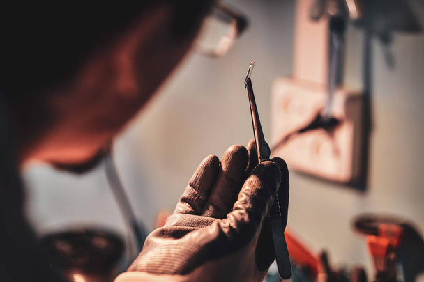 Handwerker in seiner Restaurierungswerkstatt mit Glasfrieden in den Händen. - Foto, Bild