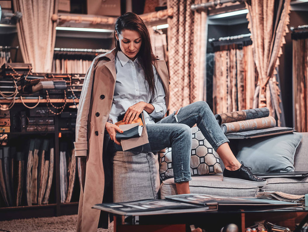 Diseñadora talentosa de moda está sentada en el sofá en su propio taller textil
 - Foto, imagen