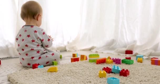 Unrecognizable baby playing with toy bricks - Filmati, video