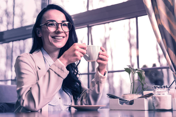 Best drink. Joyful happy woman drinking her coffee while having a break from work - Фото, изображение