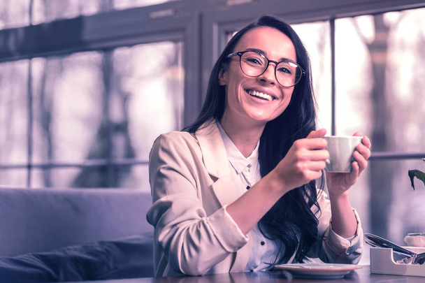 Positive emotions. Cheerful delighted businesswoman being in a great mood while drinking her favourite coffee - Foto, Imagem