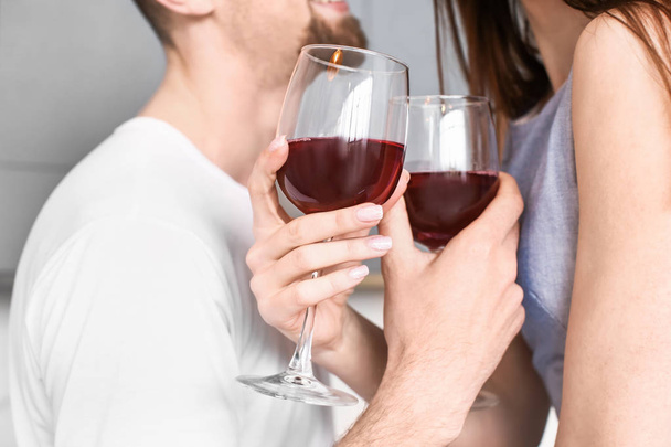 glückliches junges Paar trinkt zu Hause Wein - Foto, Bild
