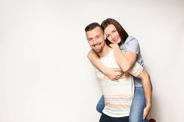 Happy young couple on light background - Foto, imagen