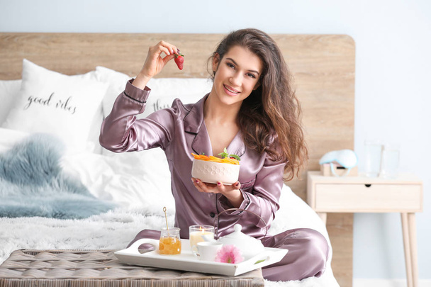 Gyönyörű fiatal nő az ágyban reggelizik - Fotó, kép