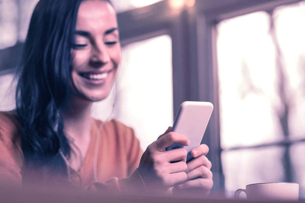 Moderni älypuhelin. Uuden modernin gadgetin valikoiva keskittyminen nuoren iloisen naisen käsiin
 - Valokuva, kuva