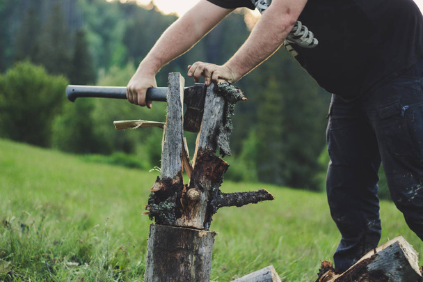 The guy is cutting an old tree in the mountains with an ax. Ukra - Fotoğraf, Görsel