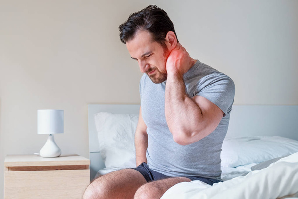 Man feeling neck stiff after sleeping in bed - Photo, Image