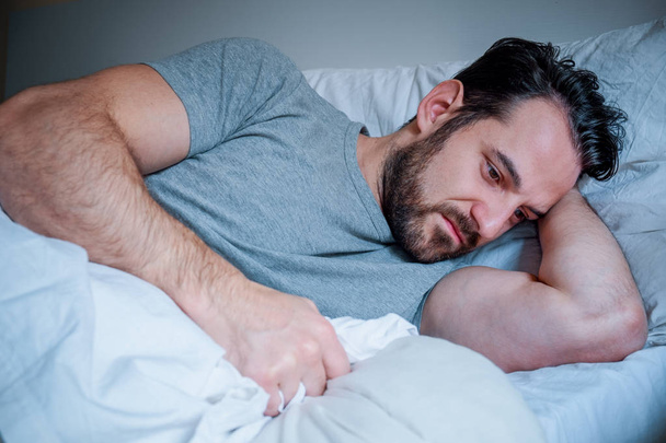 Ritratto triste uomo sdraiato nel suo letto a casa
 - Foto, immagini