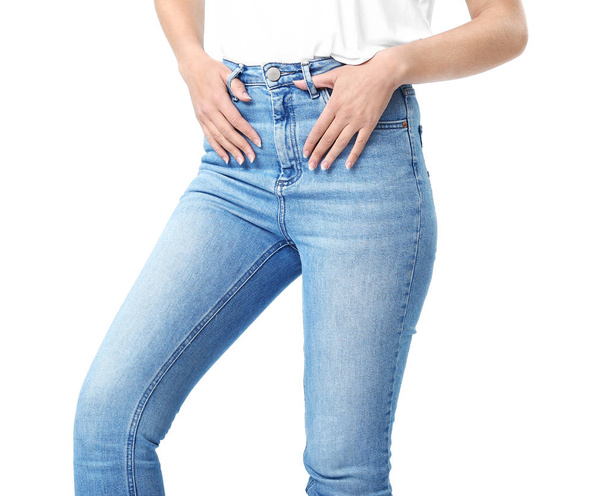 Krásná mladá žena v džínách na bílém pozadí - Fotografie, Obrázek
