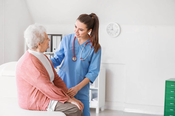 Pracownik medyczny z starszym kobietą w domu opieki - Zdjęcie, obraz