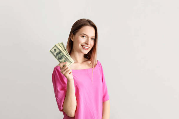 Happy young woman with money on white background - Valokuva, kuva