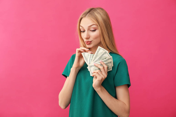 Mujer joven contando dinero en el fondo de color
 - Foto, imagen