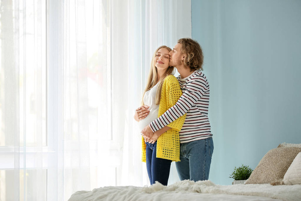 Happy young pregnant couple at home - Foto, Imagem