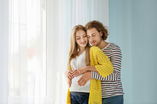 Boldog fiatal terhes pár otthon - Fotó, kép