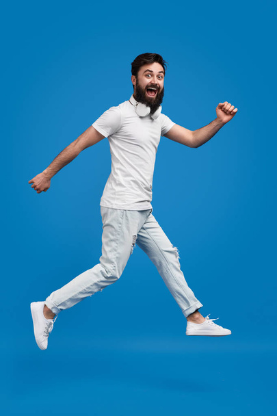 Excited hipster jumping and looking at camera - Φωτογραφία, εικόνα