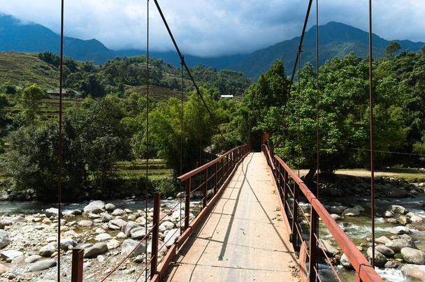 Brigde across mountain river with cold water flowing along rice terraces and small villages. Sa Pa, Vietnam  - Photo, Image