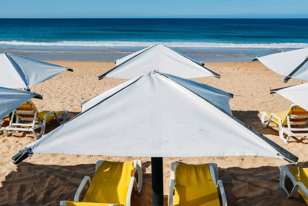 Sun loungers ja ranta sateenvarjo autiolla rannalla täydellinen loma käsite
 - Valokuva, kuva