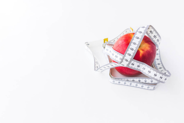 赤いリンゴは、概念の損失の重量と死のためのテープメジャーとバインドします - 写真・画像