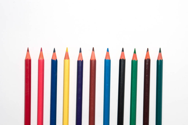 Lápices de color sobre fondo blanco vista superior. Concepto de educación, escuela, aprendizaje y creatividad
 - Foto, Imagen