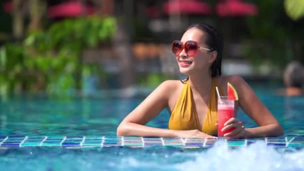 footage of beautiful asian woman relaxing in pool at hotel - Video, Çekim