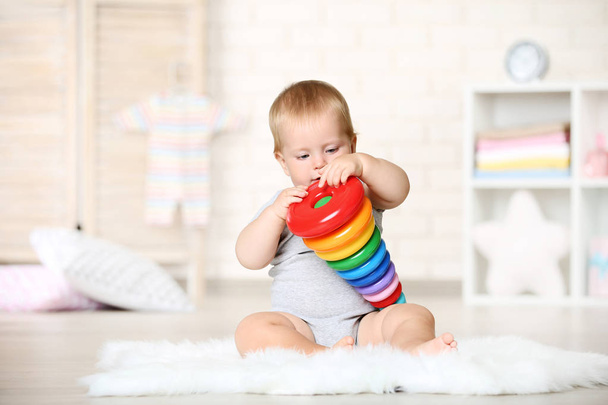 Baby boy with toys sitting on carpet at home - Zdjęcie, obraz