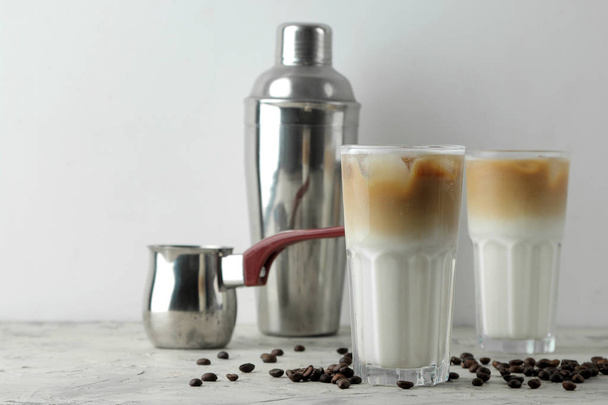 Ice latte or Iced coffee with milk and ice cubes in a glass beaker on a light background. refreshing drink. summer drink. - Fotografie, Obrázek