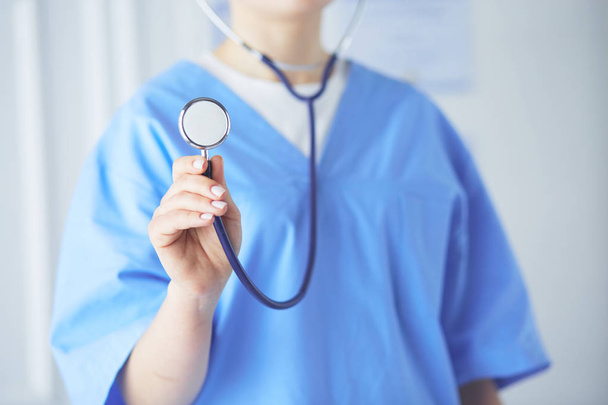 Young and confident male doctor with stethoscope in his hands. Successful doctor career concept - Photo, Image