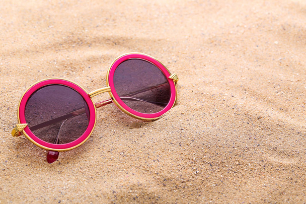 Modern sunglasses on the beach sand - Photo, Image