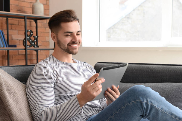 Bello uomo con tablet computer a riposo a casa
 - Foto, immagini