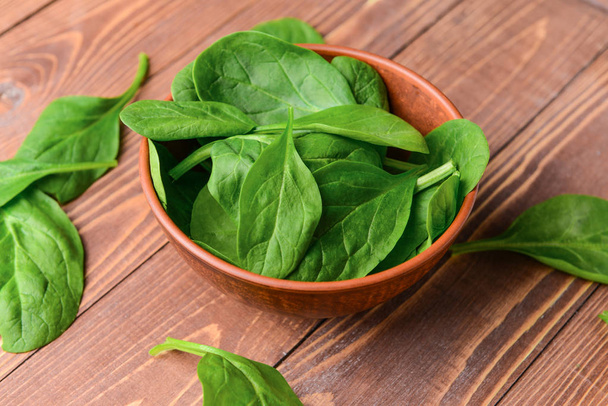 Bowl with fresh spinach on wooden background - Foto, Imagem