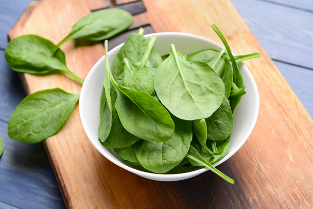 Bowl with fresh spinach on wooden board - Foto, Imagem