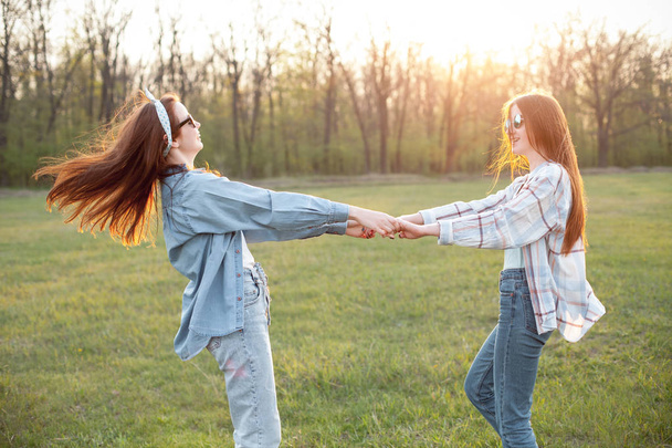 Two best friends dancing on the field under sunlight - Photo, image