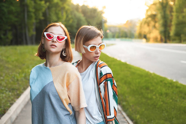 Two beautiful young women walking in the city at sunset - Fotoğraf, Görsel