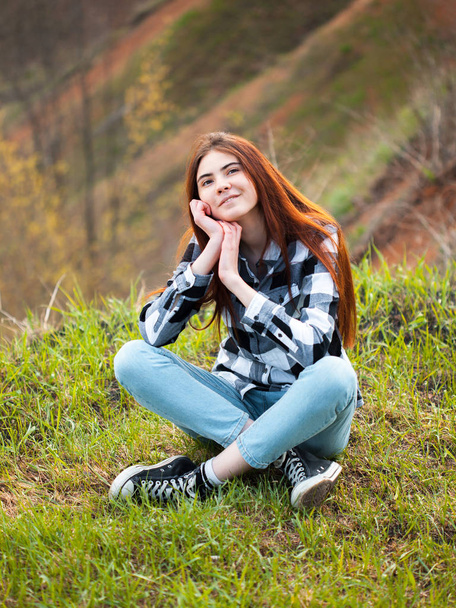 A young woman sits near to a cliff. - Fotó, kép