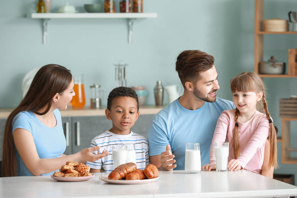 Молода сім'я п'є смачне молоко на кухні вдома
 - Фото, зображення