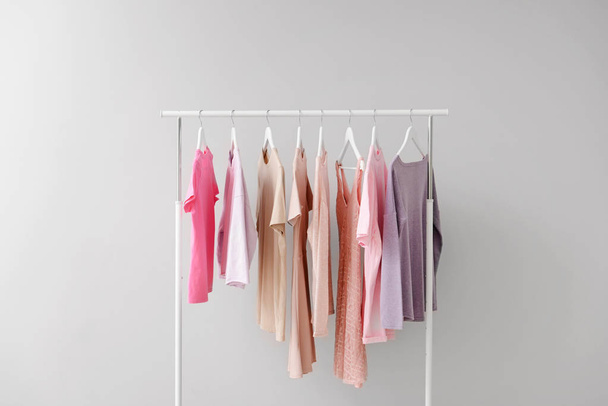 Rack with clothes after dry-cleaning on light background - Foto, Bild